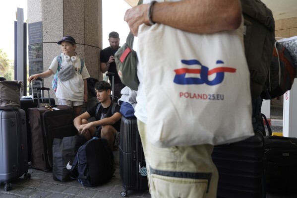 Citizens of Poland and Austria assemble at a hotel in Tel Aviv, Israel, for evacuation amid heavy strikes on Israel by Iran Tuesday, June 17, 2025. (AP Photo/Baz Ratner)
