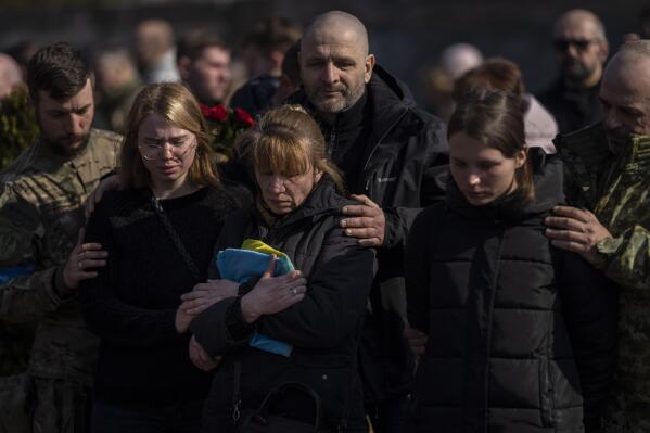 Relatives and friends attend the funeral of Ukrainian Colonel Oleg Yaschyshyn in Lviv, Ukraine, Tuesday, March 15, 2022. Yaschyshyn was killed during Sunday's Russian missile strike on a military training base near Ukraine's western border with NATO member Poland. (AP Photo/Bernat Armangue)