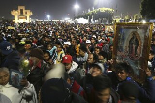 FILE - In this Dec. 12, 2019 file photo, pilgrims arrive at the plaza outside the Basilica of Our Lady of Guadalupe in Mexico City. Due to the COVID-19 pandemic, the Mexican Catholic Church announced on Monday, Nov. 23, 2020 the cancelation of the annual pilgrimage, the largest Catholic pilgrimage worldwide. (AP Photo/Marco Ugarte, File)