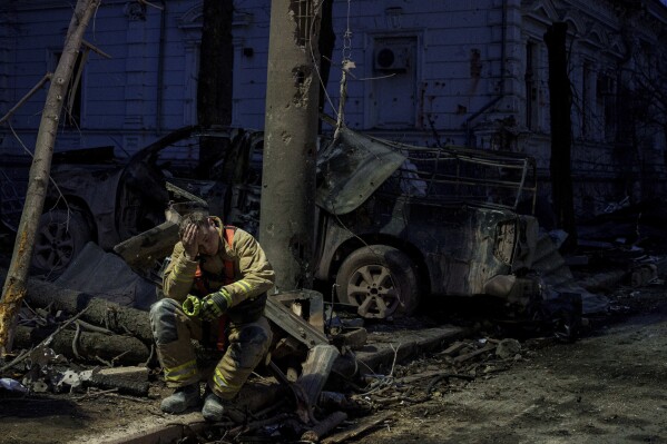 A rescue worker rests near university building destroyed by a Russian missile strike on Sumy, Ukraine, Sunday, April 13, 2025. (AP Photo/Evgeniy Maloletka)