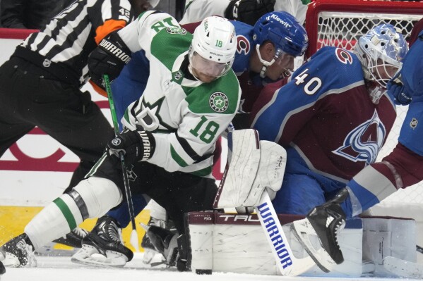 Dallas Stars center Sam Steel, front left, tries to put the puck past Colorado Avalanche goalie Alexander Georgiev (40) in the third period of a preseason NHL hockey game Sunday, Oct. 1, 2023, in Denver. (AP Photo/David Zalubowski)