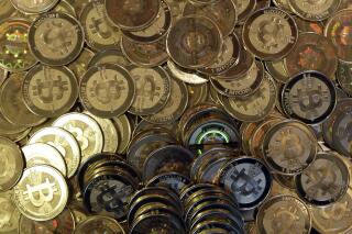 FILE - This April 3, 2013, file photo shows bitcoin tokens in Sandy, Utah. The Cuban government said Thursday, August 26, 2021, that it will start recognizing cryptocurrencies like Bitcoin as payment. (AP Photo/Rick Bowmer, File)