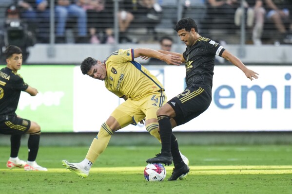Los Angeles FC forward Carlos Vela, right, dribbles under pressure by Real Salt Lake defender Brayan Vera (4) during the first half of an MLS soccer match Sunday, Oct. 1, 2023, in Los Angeles. (AP Photo/Jae C. Hong)