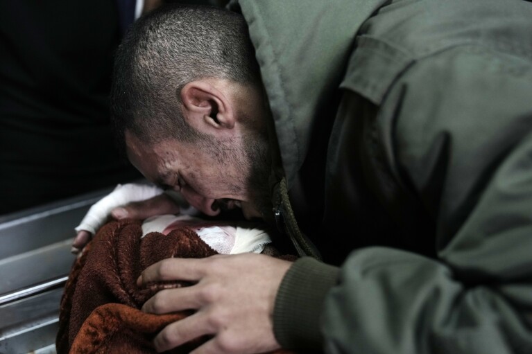 A Palestinian mourner bids farewell to one of three men killed by Israeli fire in Faraa refugee camp, at the morgue in the West Bank town of Tubas, Tuesday, Feb. 27, 2024. Israeli troops shot and killed three Palestinian men including Mohammed Daraghmeh, a co-founder of the local branch of Islamic Jihad in the northern town of Tubas, early Tuesday, Palestinian health authorities said. Thee was no immediate comment from the Israeli military. (AP Photo/Majdi Mohammed)