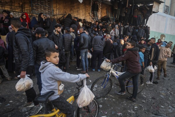 Palestinian crowds struggle to buy bread from a bakery in Rafah, Gaza Strip, Monday, Feb. 19, 2024. International aid agencies say Gaza is suffering from shortages of food, medicine and other basic supplies as a result of the war between Israel and Hamas. (AP Photo/Mohammed Dahman)