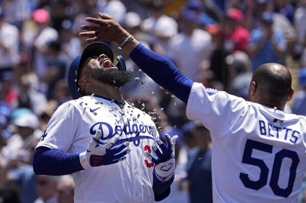 Los Angeles Dodgers' Teoscar Hernández, left, is hit with sunflower seeds thrown by Mookie Betts after hitting a two-run home run during the sixth inning of a baseball game against the Miami Marlins Wednesday, May 8, 2024, in Los Angeles. (AP Photo/Mark J. Terrill)