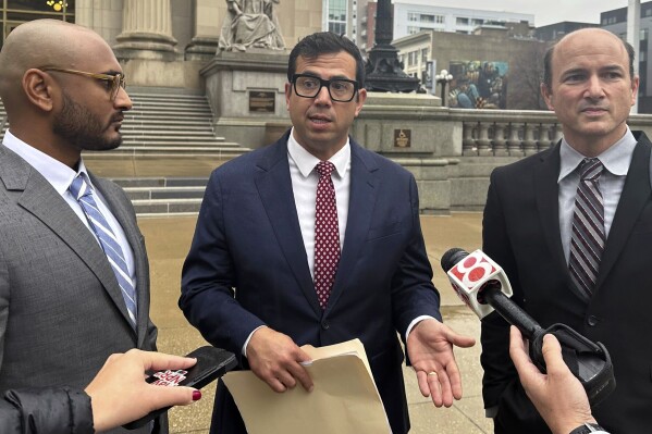 From left, Chiraayu Gosrani, Nicholas Espíritu and Gavin Rose, who represent five plaintiffs, speak to reporters outside the Bayh Federal Building U.S. Courthouse in Indianapolis on Friday, Nov. 17, 2023. A federal judge heard arguments Friday on behalf of five Indiana residents from Haiti who say a recently passed state law discriminates based on national origin. (AP Photo/Isabella Volmert)