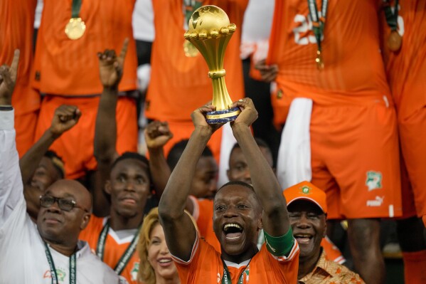 Ivory Coast 's Max-Alain Gradel lifts the trophy after winning the African Cup of Nations final soccer match between Nigeria and Ivory Coast, at the Olympic Stadium of Ebimpe in Abidjan, Ivory Coast, Sunday, Feb. 11, 2024. (AP Photo/Sunday Alamba)