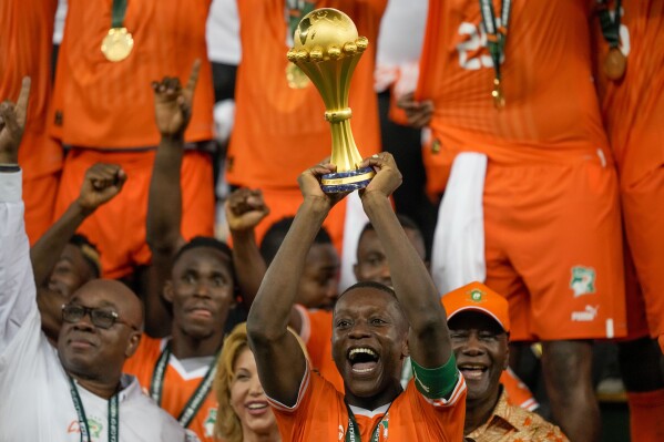 Ivory Coast 's Max-Alain Gradel lifts the trophy after winning the African Cup of Nations final soccer match between Nigeria and Ivory Coast, at the Olympic Stadium of Ebimpe in Abidjan, Ivory Coast, Sunday, Feb. 11, 2024. (AP Photo/Sunday Alamba)