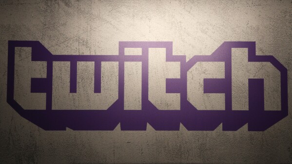 FILE - The logo for live-streaming video platform Twitch is seen on Nov. 4, 2017, at the Paris games week in Paris, France. Twitch is laying off more than 500 employees, Wednesday, Jan. 10, 2024, as the company looks to get to a more appropriate size, according to the streaming platform's CEO Dan Clancy. (AP Photo/Christophe Ena, File)