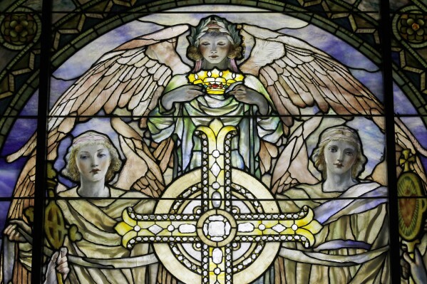FILE - A detail of "The Righteous Shall Receive a Crown of Glory," Brainard Memorial Window for Methodist Church, Waterville, New York, ca. 1901 is photographed while on display at the "Louis C. Tiffany and the Art of Devotion" exhibit at the Museum of Biblical Art in New York on Thursday, Oct. 25 2012. About 7 in 10 U.S. adults say they believe in angels, according to a new poll released on Saturday, July 29, 2023, by The Associated Press-NORC Center for Public Affairs Research. (AP Photo/Mary Altaffer, File)