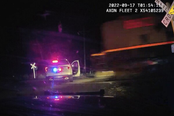 FILE - This screen grab from dash camera video provided by the Fort Lupton Police Department shows a freight train barreling toward a parked police car with a suspect inside, Sept. 16, 2022, in Fort Lupton, Colo. A former Fort Lupton Police officer, Jordan Steinke, was sentenced to 30 months on supervised probation on Friday, Sept. 15, 2023, for placing the handcuffed suspect in the car on the tracks. The collision seriously injured 21-year-old Yareni Rios-Gonzalez. The date/time stamp shown on the video is incorrect. (Fort Lupton Police Department via AP, File)