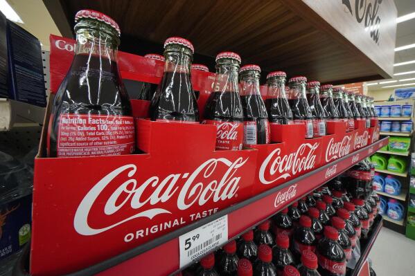 Bottles of Coca-Cola are on display at a grocery market in Uniontown, Pa, on Sunday, April 24, 2022. Coca-Cola raised prices to offset inflation and on Tuesday, Feb. 14, 2023, it said that it didn't dent demand for its drinks during the fourth quarter. (AP Photo/Gene J. Puskar)