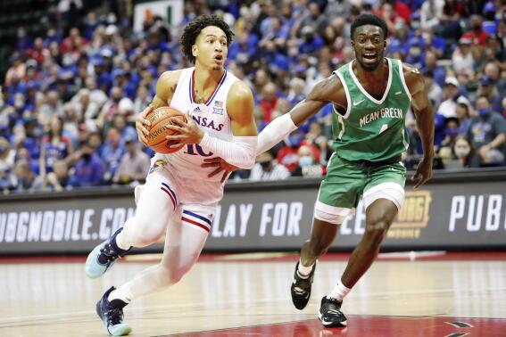 Kansas forward Jalen Wilson, left, drives to the basket in front of North Texas forward Thomas Bell during the first half of a NCAA college basketball game Thursday, Nov. 25, 2021, in Orlando, Fla. (AP Photo/Jacob M. Langston)