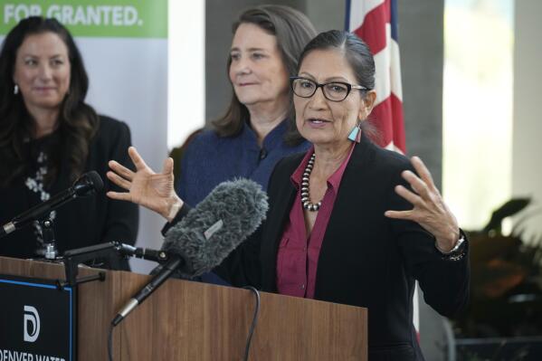 As Becky Mitchell, back left, and of the Colorado Water Conservation Board, and U.S. Rep Diana DeGette, D-Colo., look on, Interior Secretary Deb Haaland speaks during a news conference after Haaland's visit to talk about federal solutions to ease the effects of the drought at the offices of Denver Water Thursday, July 22, 2021, in Denver. Haaland will make stops in two cities on Colorado's Western Slope as part of her trip to assess the effects of the drought on the Centennial State. (AP Photo/David Zalubowski)