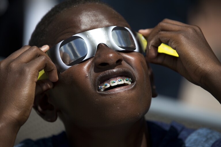 FILE - Blake Davis, 10, of Coral Springs, Fla., looks through solar glasses as he watches the eclipse, Monday, Aug. 21, 2017, at Nova Southeastern University in Davie, Fla. After April 8, 2024, there won鈥檛 be another U.S. eclipse, spanning coast to coast, until 2045. That one will stretch from Northern California all the way to Cape Canaveral, Florida. (AP Photo/Wilfredo Lee, File)