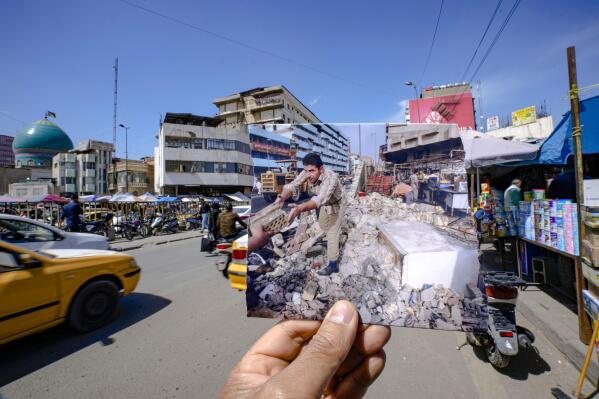 A photograph of Iraqi men clearing then rubble of a collapsed market wall after a roadside bomb went off targeting a US patrol followed by fire exchange between US troops and gunmen in central Baghdad Thursday Oct. 19, 2006, is inserted into the scene at the same location Monday, March 20, 2023, 20 years after the American led invasion on Iraq and subsequent war. (AP Photo/Hadi Mizban)