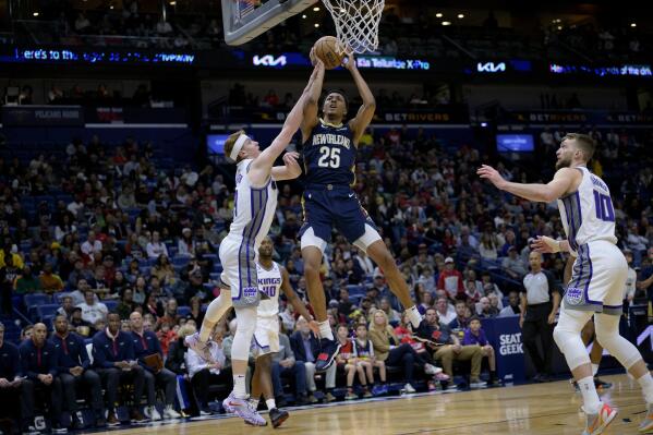 New Orleans Pelicans guard Trey Murphy III (25) scores against Sacramento Kings guard Kevin Huerter (9) in the first half of an NBA basketball game in New Orleans, Sunday, Feb. 5, 2023. (AP Photo/Matthew Hinton)