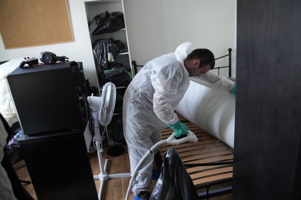 Pest control technician Lucas Pradalier sprays steam on a bed in a Paris apartment, Wednesday, Oct. 4, 2023. The French government has been forced to step in to calm a nation increasingly anxious about bedbugs. (AP Photo/Christophe Ena)