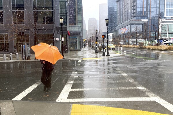 FILE - A person braces against the wind as a wintry mix of snow and rain falls in Boston, March 14, 2023. A winter weather system moving through the U.S. is expected to wallop the East Coast this weekend, Saturday, Jan. 6, 2024, into Sunday, Jan. 7, with a mix of snow and freezing rain from the southern Appalachians to the Northeast — although it's too early to say exactly which areas will get what precipitation and how much. (AP Photo/Michael Casey, File)