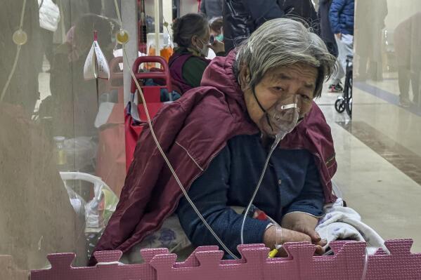 An elderly patient receives an intravenous drip while using a ventilator in the hallway of the emergency ward in Beijing, Thursday, Jan. 5, 2023. Patients, most of them elderly, are lying on stretchers in hallways and taking oxygen while sitting in wheelchairs as COVID-19 surges in China's capital Beijing. (AP Photo/Andy Wong)