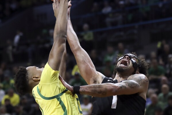 Colorado guard J'Vonne Hadley, right, drives to the basket as Oregon forward Kwame Evans Jr., left, defends during the second half of an NCAA college basketball game Thursday, March 7, 2024, in Eugene, Ore. Colorado won 79-75. (AP Photo/Amanda Loman)