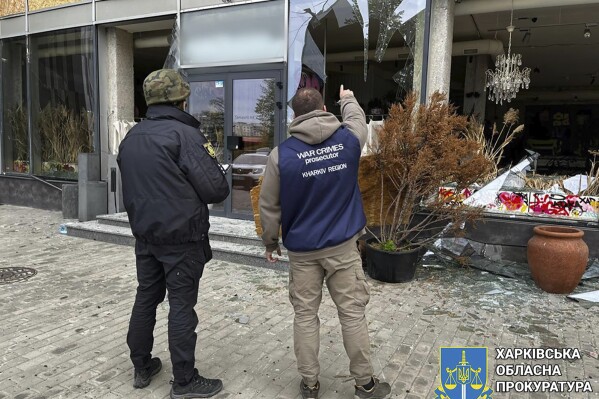 In this photo provided by Kharkiv Regional Prosecutor's Office, war crime prosecutors inspect the scene after Russia's attack in Kharkiv, Ukraine, Wednesday, April 24, 2024. (Kharkiv Regional Prosecutor's Office/ via AP)