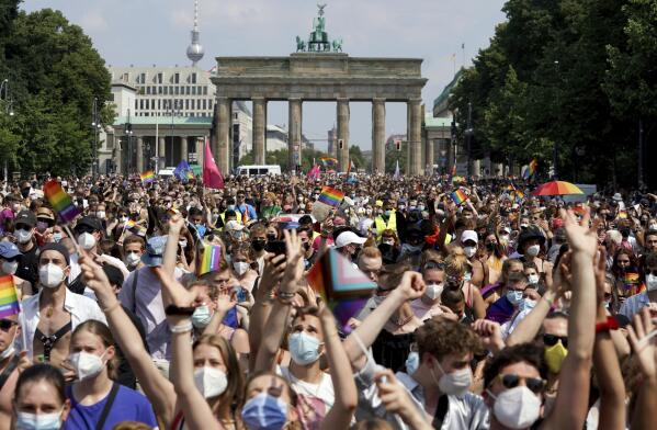 Thousands of people take part in the Christopher Street Day (CSD) parade, with the Brandenburg Gate in the background in Berlin, Germany, Saturday July 24, 2021.  (Jorg Carstensen/dpa via AP)