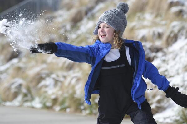 Ian Mattson, 9, throws a snowball at his sister Elise, 5, as they play in Renaissance Park on Saturday, March 12, 2022 In Chattanooga, Tenn.  (Matt Hamilton /Chattanooga Times Free Press via AP)