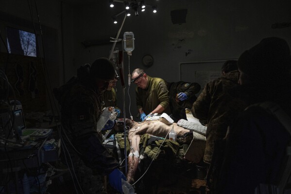 Ukrainian military doctors treat their injured comrade who was evacuated from the battlefield at the hospital in Donetsk region, Ukraine,  Jan. 9, 2023. The serviceman did not survive. (AP Photo/Evgeniy Maloletka)