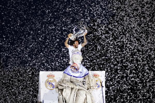 FILE - Real Madrid player Marcelo holds the trophy at Cibeles Square in front of the City Hall in Madrid, Spain, May 29, 2022. A group of top soccer clubs face Champions League organizer UEFA in court on Monday, July 11, 2022, for a legal match that risks the biggest upheaval in European soccer for more than 25 years. The Super League project failed at launch 15 months ago but the company formed by the 12 rebel clubs — now led by Real Madrid, Barcelona and Juventus — has brought a case to the Court of Justice of the European Union in Luxembourg. (AP Photo/Andrea Comas, File)