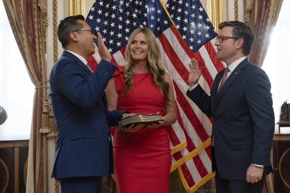 Speaker of the House Mike Johnson, R-La., right, administers the House oath of office to Rep. Vince Fong, R-Calif., during a ceremonial swearing-in on Capitol Hill in Washington, Monday June 3, 2024. Amanda Fong holds the Bible. ( AP Photo/Jose Luis Magana)