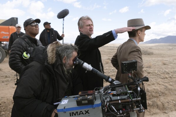 This image released by Universal Pictures shows director Christopher Nolan, center, and Cillian Murphy, right, on the set of "Oppenheimer." (Melinda Sue Gordon/Universal Pictures via AP)