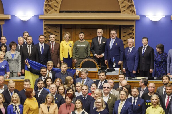 Ukrainian President Volodymyr Zelenskyy, center, with Estonia's President Alar Karis, center right, and Estonia's Prime Minister Kaja Kallas, center left, pose for a group photo with parliamentarians after giving a speech to the Riigikogu, or Estonian parliament, in Tallinn, Estonia, Thursday, Jan.11, 2024. (AP Photo)