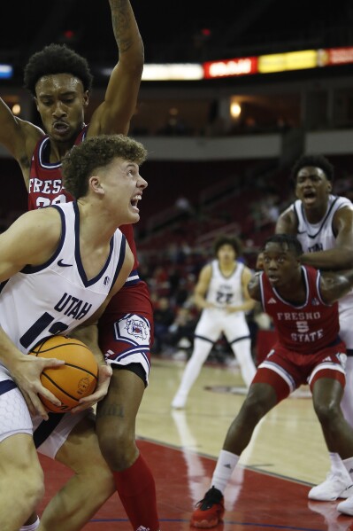 Mason Falslev, de Utah State, se enfrenta con fuerza a Leo Colimerio, de Fresno State, durante la primera mitad de un partido de baloncesto universitario de la NCAA en Fresno, California, el martes 27 de febrero de 2024. (Foto AP/Gary Kazanjian)