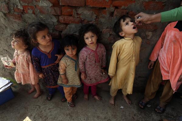 A health worker administers a polio vaccine to a child in Lahore, Pakistan, Monday, Feb. 28, 2022. (AP Photo/K.M. Chaudary)
