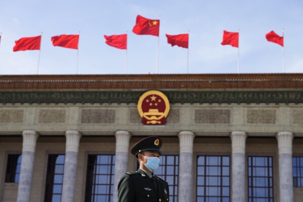 File - A Chinese soldier stands guard outside the Great Hall of the People after the opening ceremony of The Third Belt and Road Forum in Beijing, Oct. 18, 2023. In China, growth is hobbled by the collapse of an overbuilt real estate market, sagging consumer confidence and high rates of youth unemployment. (AP Photo/Ng Han Guan, File)