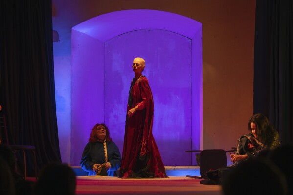 Actresses perform male roles on the stage of the Chernihiv Regional Youth Theater, which reinvented itself with an all-female cast, with most male actors at war, in Chernihiv, Ukraine, Sunday, Feb. 16, 2025. (AP Photo/Efrem Lukatsky)