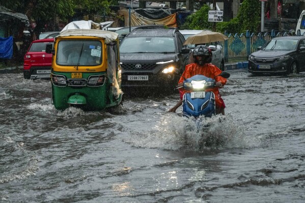Vehicles move through a waterlogged street in Kolkata, India, as rain continues after cyclone Remal made a landfall near Bangladesh-India border, Monday, May 27, 2024. (AP Photo/Bikas Das)