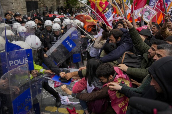 Union members clash with Turkish anti riot police officers as they march during Labor Day celebrations in Istanbul, Turkey, Wednesday, May 1, 2024. Police in Istanbul used tear gas and fired rubber bullets to disperse thousands of people attempting to break through a barricade and reach the city's main city's main square, Taksim, in defiance of a government ban on celebrating May 1 Labor Day at the landmark location. (AP Photo/Khalil Hamra)