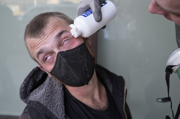 A man receives treatment after tear gas was deployed during a protest Saturday, June 14, 2025, in Portland, Ore. (AP Photo/Jenny Kane)