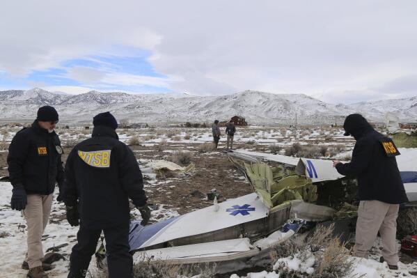 This photo provided by The National Transportation Safety Board shows NTSB investigators on Sunday, Feb. 26, 2023, at the crash site in Dayton, Nev. documenting the wreckage of a Pilatus PC-12 airplane a medical air transport flight operated by Guardian Flight that crashed on Friday, Feb. 24, while enroute from Reno, Nevada, to Salt Lake City. (NTSB via AP)