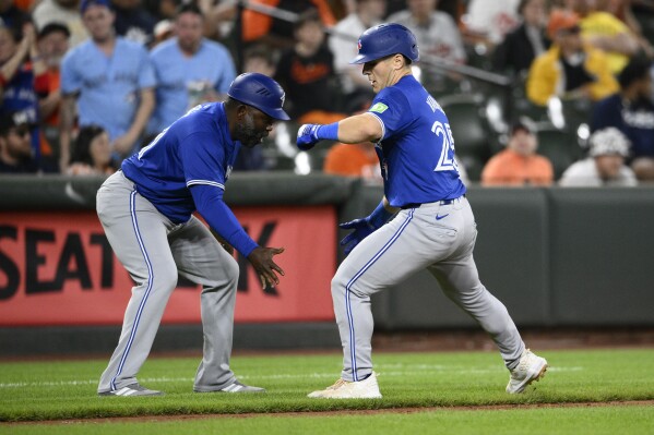 Toronto Blue Jays' Daulton Varsho, right, celebrates his home run with third base coach Carlos Febles, during the eighth inning of a baseball game against the Baltimore Orioles, Monday, May 13, 2024, in Baltimore. (AP Photo/Nick Wass)