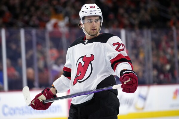 FILE - Michael McLeod of the New Jersey Devils watches during a break in an NHL hockey game on Thursday, Nov. 30, 2023, in Philadelphia. McLeod has been charged in connection with an investigation into allegations of sexual assault by several members of Canada's 2018 World Junior Team, his lawyer announced on Tuesday, January 30, 2024.  (AP Photo/Matt Slocum, File)