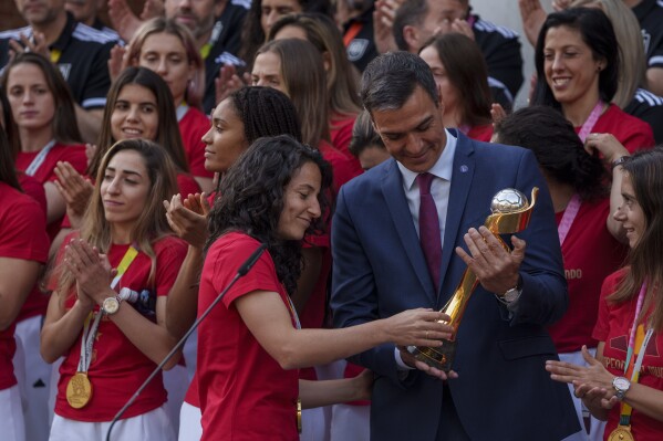 Spain's acting Prime Minister Pedro Sanchez holds the trophy next to Spain's Ivana Andres after their World Cup victory, at La Moncloa Palace in Madrid, Spain, Tuesday, Aug. 22, 2023. Spain beat England in Sydney Sunday to win the Women's World Cup soccer final. (AP Photo/Manu Fernandez)