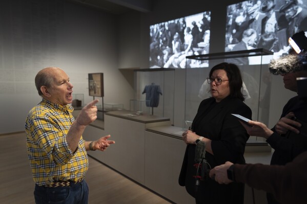 Philippe DelMonte, left, a Holocaust survivor, is interviewed with the help of sign language interpreter Melanie Moll, right, during a press preview of the new Holocaust Museum in Amsterdam, Netherlands, Tuesday, March 5, 2024. (AP Photo/Peter Dejong)