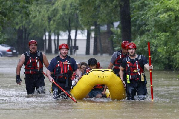 FILE - Members of the Balch Springs Fire Department bring a family of four by boat to higher ground after rescuing them from their home along Forest Glen Lane in Batch Springs, Texas, Aug. 22, 2022. This summer the weather has not only been extreme, but it has whiplashed from one extreme to another. Dallas, St. Louis, Kentucky, Yellowstone, Death Valley all lurched from drought to flood. (Elías Valverde II/The Dallas Morning News via AP, File)/The Dallas Morning News via AP)