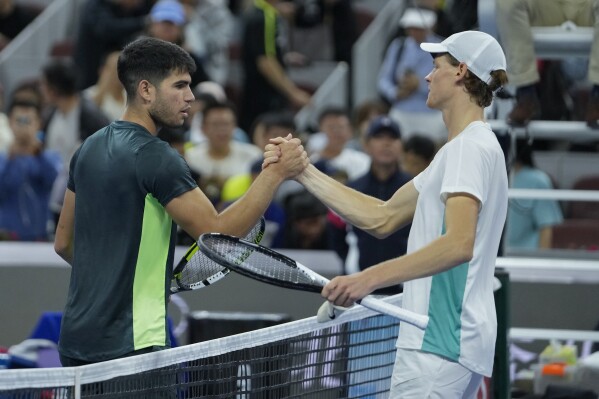 Jannik Sinner of Italy, right, shakes hands with Carlos Alcaraz of Spain after beating him in the men's singles semifinal match of the China Open tennis tournament at the Diamond Court in Beijing, Tuesday, Oct. 3, 2023. (AP Photo/Andy Wong)