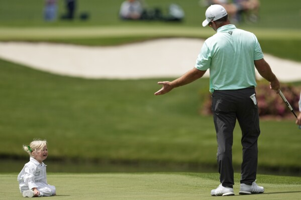 Ryan Fox, of New Zealand, gestures towards his crying daughter Isobel on the fourth hole during the par-3 contest at the Masters golf tournament, at the Augusta National Golf Club in Augusta, Ga., April 10, 2024. (AP Photo/George Walker IV)