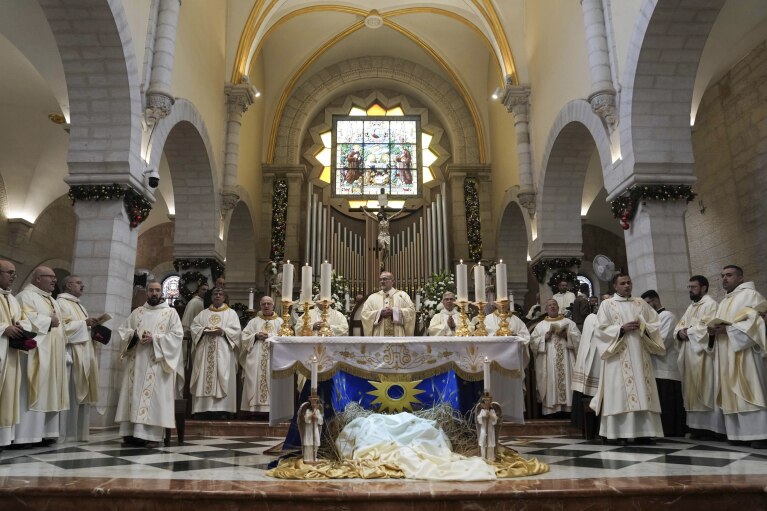 Latin Patriarch Pierbattista Pizzaballa, center, leads the Christmas morning Mass at the Chapel of Saint Catherine, traditionally believed to be the birthplace of Jesus, in the West Bank city of Bethlehem, Monday, Dec. 25, 2023. Bethlehem is having a subdued Christmas after officials in Jesus' traditional birthplace decided to forgo celebrations due to the Israel-Hamas war. (AP Photo/Mahmoud Illean)